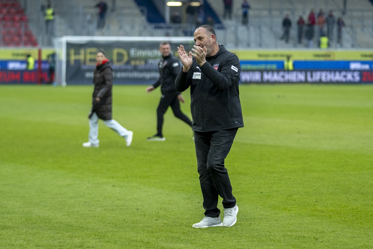 Trainer applaudierend am Spielfeldrand